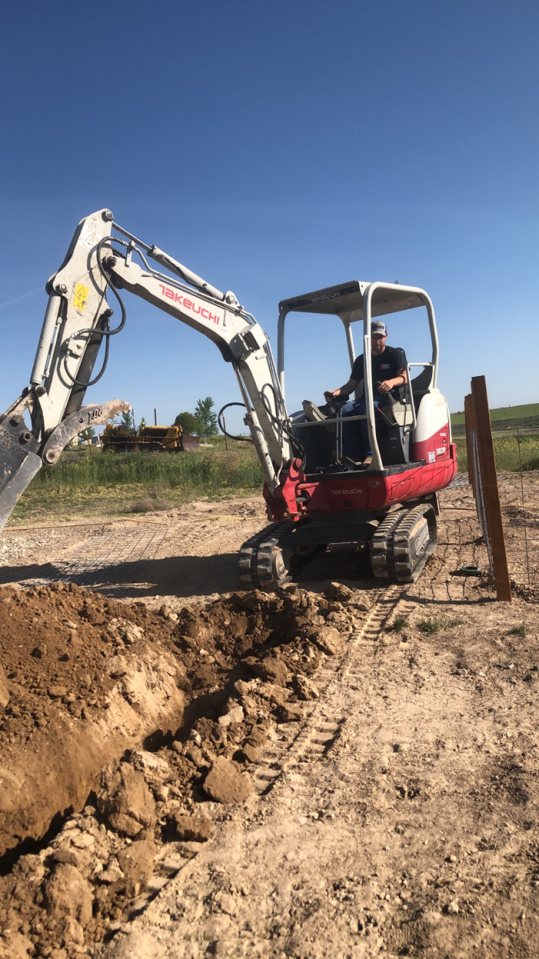 Mini excavator trenching a footing on a job site