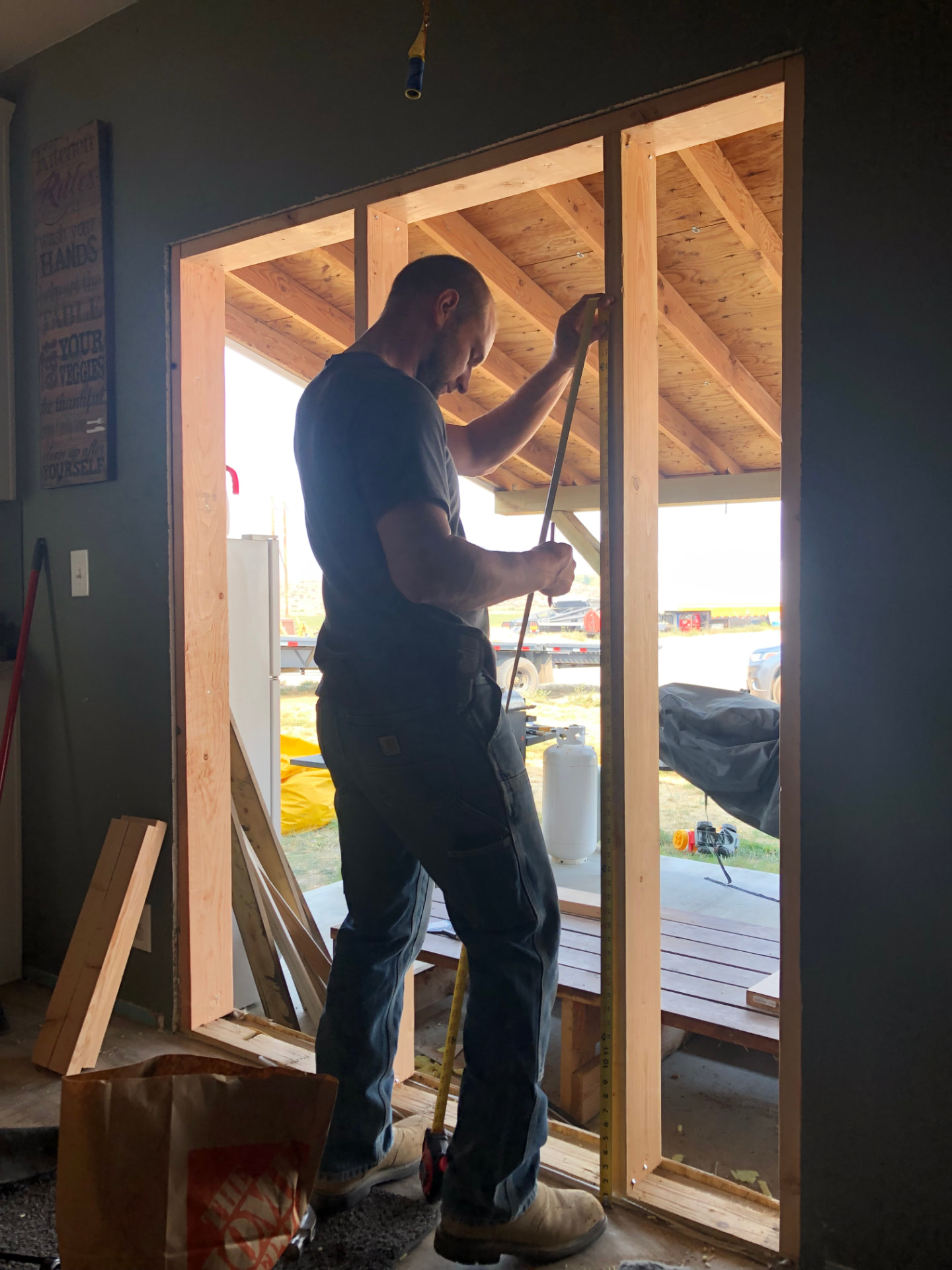 Crew member measuring a new framed opening during a rebuild